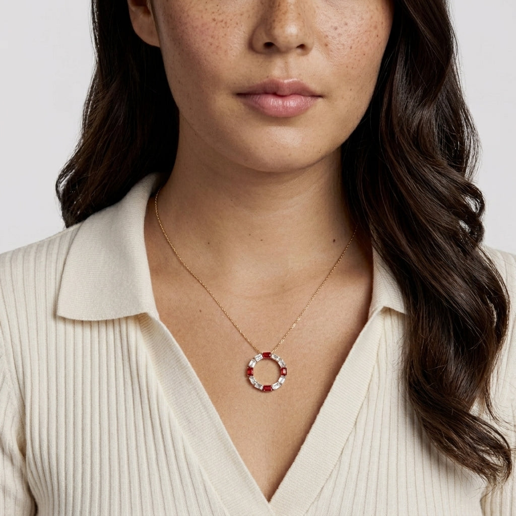 Woman wearing a necklace with a circular pendant on a plain background