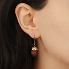 Close up of a woman wearing Petite Round Maroon Howlite Quartz Gemstone Drop Earrings