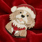 Puppy in a Santa outfit brooch resting on red satin fabric 