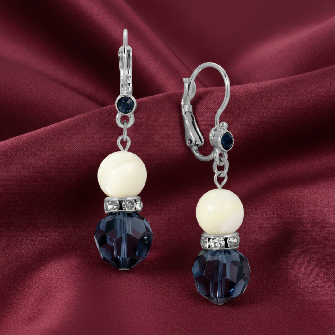 Pair of earrings with mother of pearl and blue crystal on a red fabric background