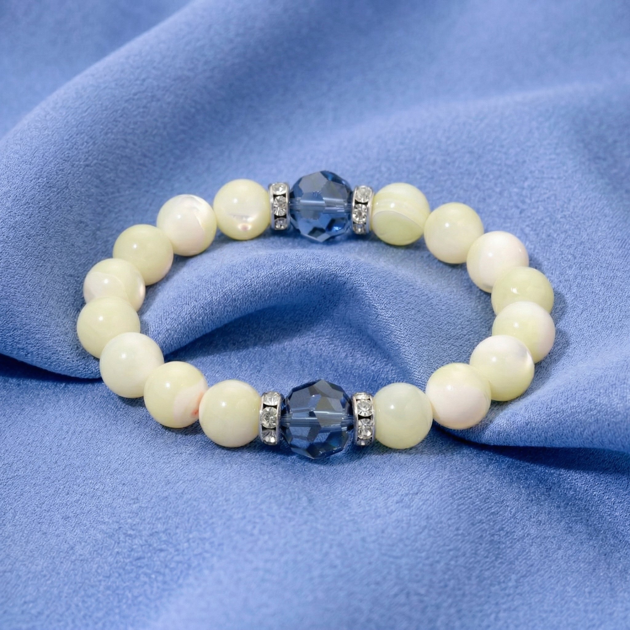 Pearl bracelet with blue and clear beads on a blue fabric background