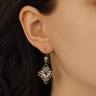 Close up of a model wearing a Gold Filigree Diamond Shape Peach Stone Drop Earrings