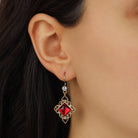 Close up of a female model wearing Gold Filigree & Diamond Shaped Ruby Crystal Drop Earrings