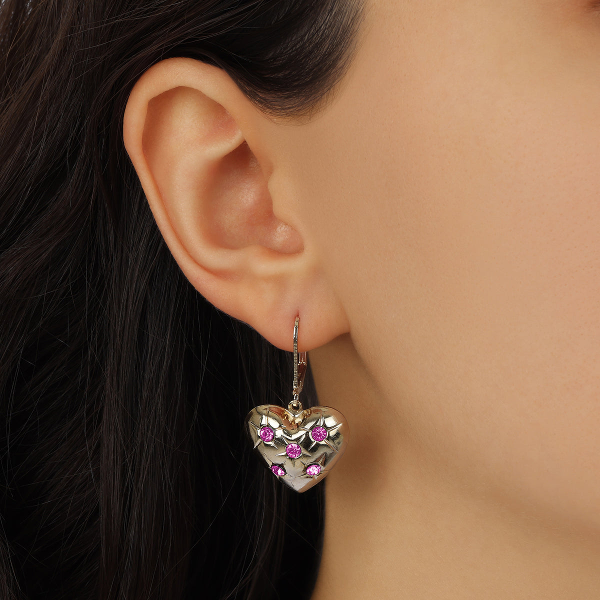 A close-up of a model's ear wearing a Hearts of Gold & Pink Crystal Drop Earrings