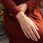 Woman in a fall outfit wearing a Rose Pink European Glass Lantern Crystal & Gold Beaded Bracelet on her wrist
