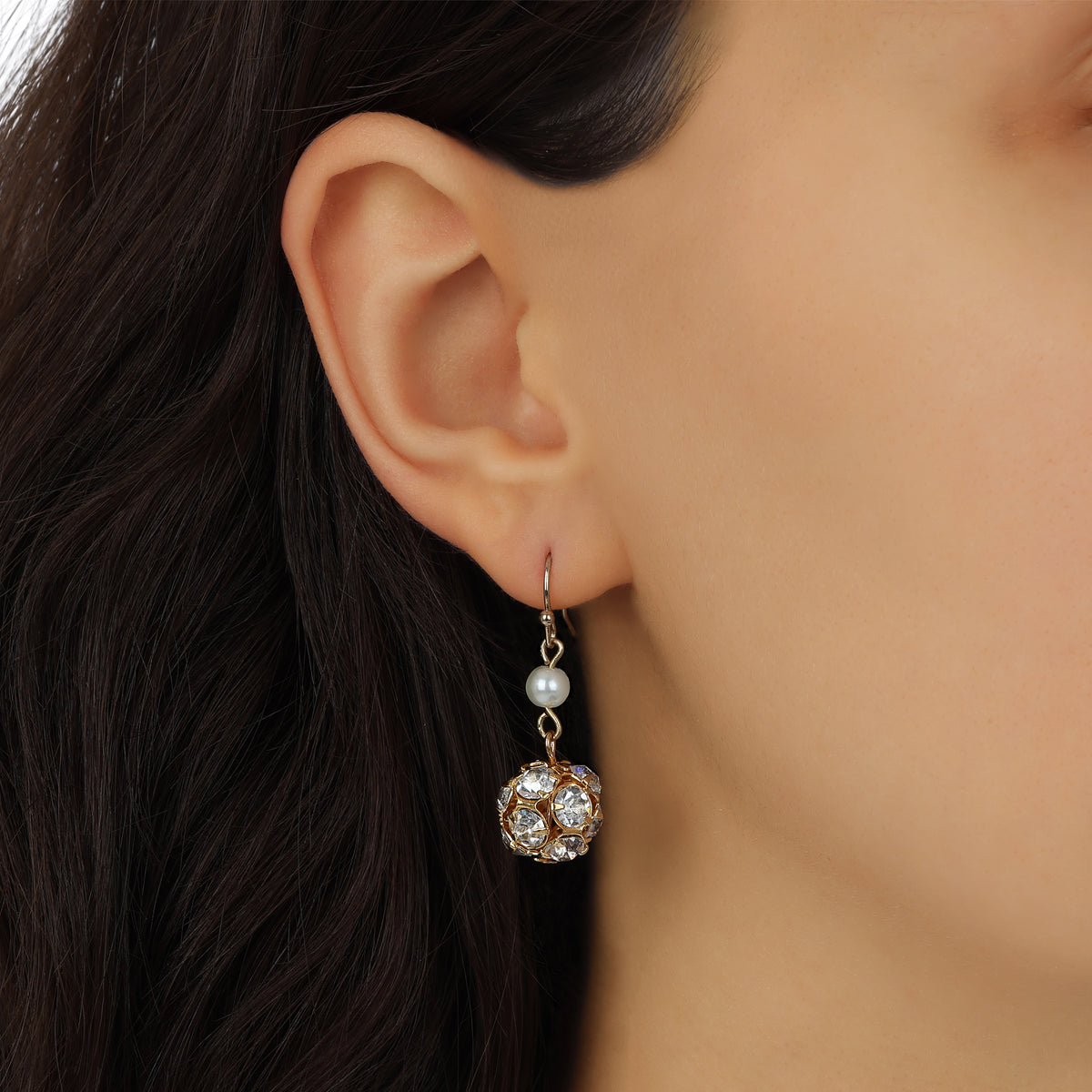 A close-up of a model's ear wearing Clustered Fireball Crystals & Round Faux Pearl Drop Earrings