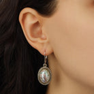 A close-up of a model's ear wearing a Pink Floral Dotted Oval Faux Pearl Drop Earrings