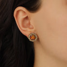 A close-up of a model's ear wearing a Golden Round Stone & Harvest Flower Decal Stud Earrings