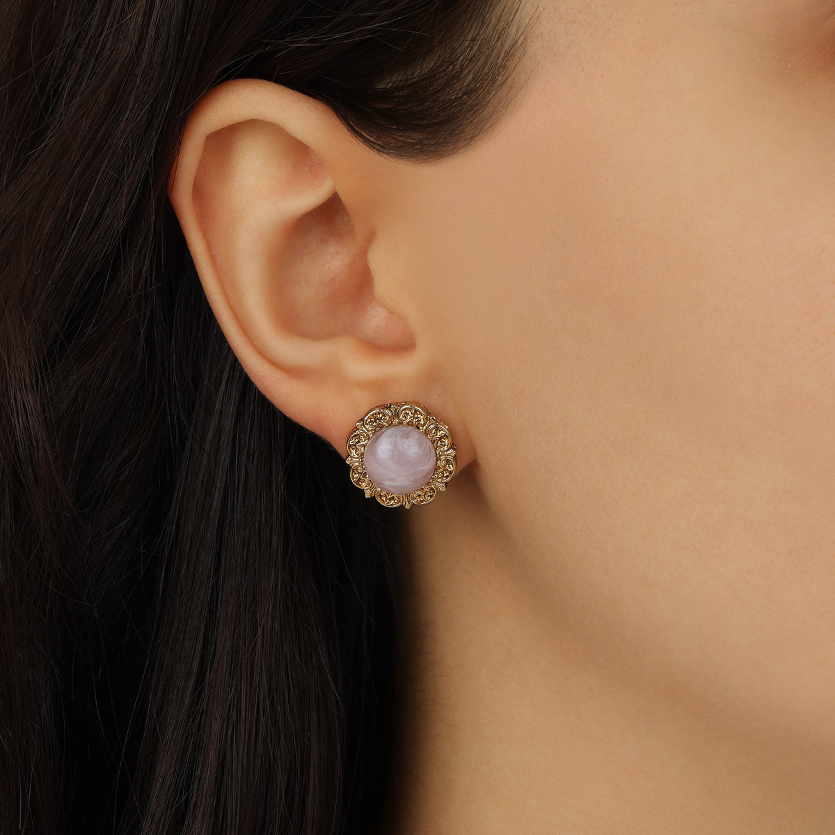 A close-up of a model's ear wearing a Round Pink Rose Quartz Stone Stud Earring