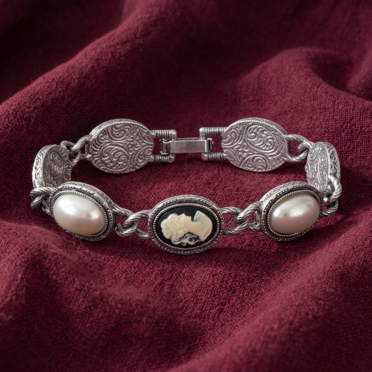 Vintage Style Black Cameo Stone & Grey Faux Pearl Link Bracelet displayed on draped burgundy fabric.