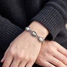 Vintage Style Black Cameo Stone & Grey Faux Pearl Link Bracelet shown worn on a person's wrist with dark ribbed knit sleeves visible.