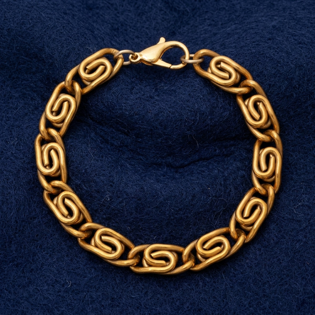 A gold-toned chain bracelet with interlocking spiral links and a lobster clasp, displayed on a textured dark navy blue background.