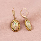 Pink Floral Oval Faux Pearl Decal Drop Earrings resting on pink linen