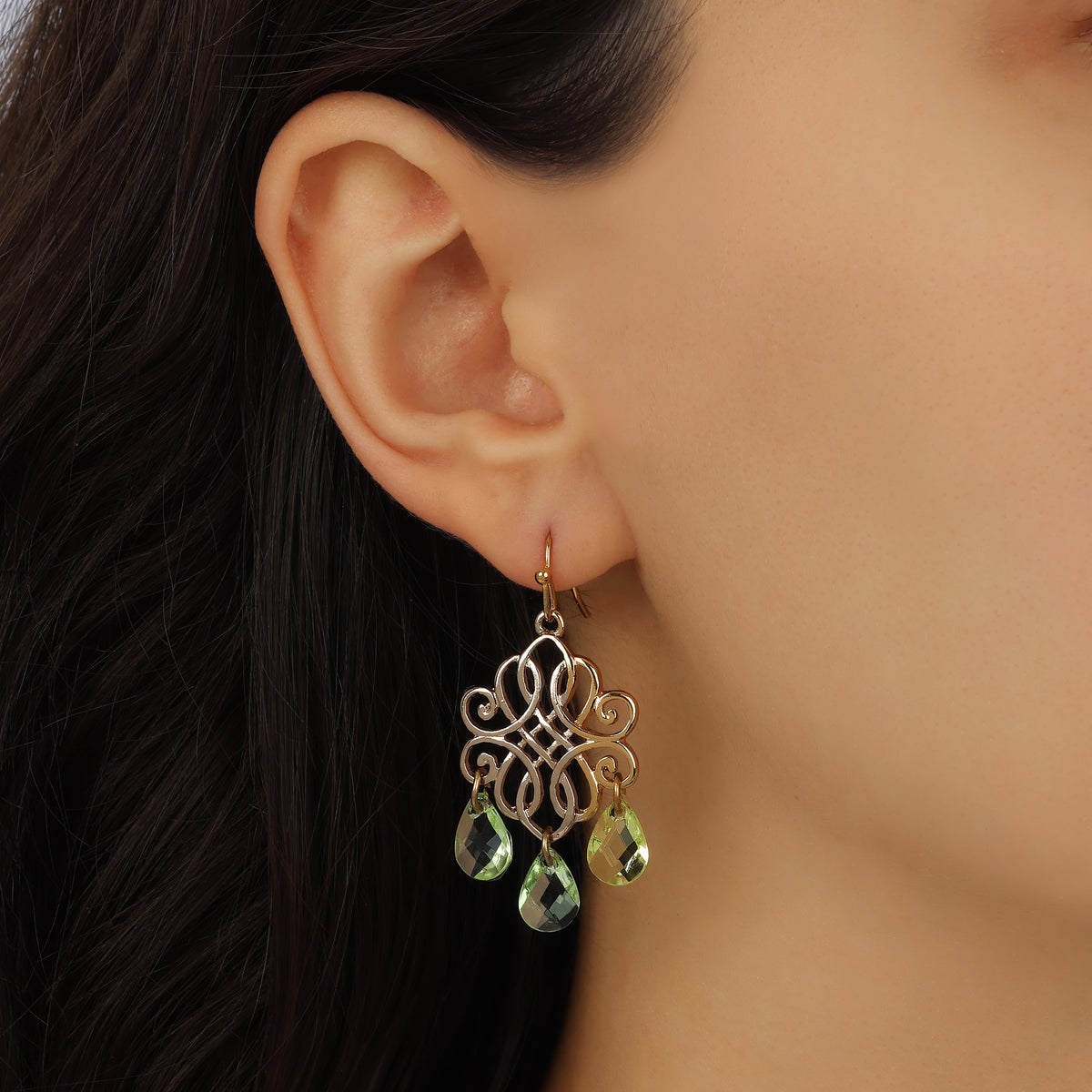 A close-up of a model's ear wearing Golden Filigree & Dangling Briolette Teardrop Bead Earrings