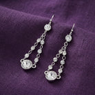 Twin Chain Multi Austrian Crystal Vintage Dangle Earrings displayed on a textured purple fabric background.