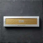 1928 Jewelry box with brand logo and "Then. Now. Forever." slogan resting on a smooth black stone surface