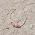 Pink Peppermint Beaded & Faux Pearl Chain Necklace 15" + 3" Extension, displayed on a textured light gray stone surface.