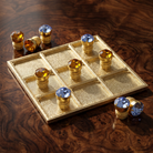 Parlor Tic-Tac-Toe Board Set With Light Sapphire Blue & Topaz Crystal Pieces resting on a dark wooden coffee table