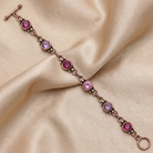 Bracelet with pink gemstones on a beige satin background