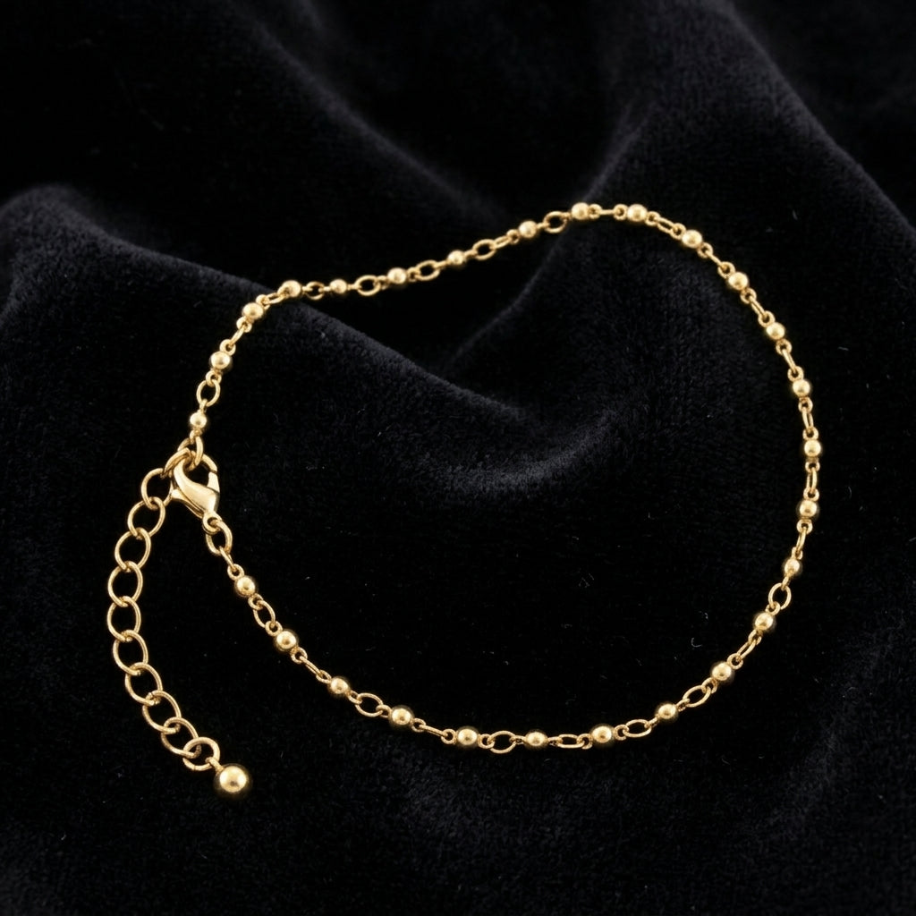 Gold tone anklet on black fabric