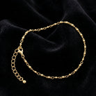 Gold tone anklet on black fabric