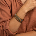 A close-up of a person wearing a Waxed Linen & Rhinestone Bangle Bracelet