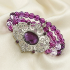 Purple beaded bracelet with an ornate silver clasp on a beige fabric background