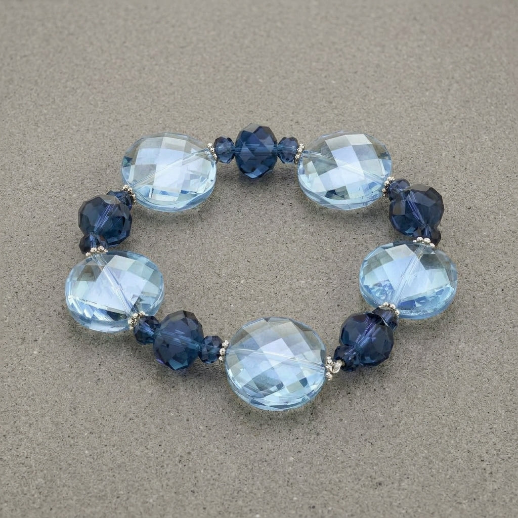 Montana Blue & Light Sapphire Blue Faceted Stone Stretch Bracelet displayed on a textured gray stone background.