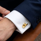 Gold cowboy hat cufflink on a white cuff against a navy suit background