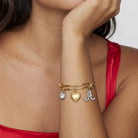 Woman in a red dress wearing our Gold Heart Initial Crystal Charm Bangle Bracelet