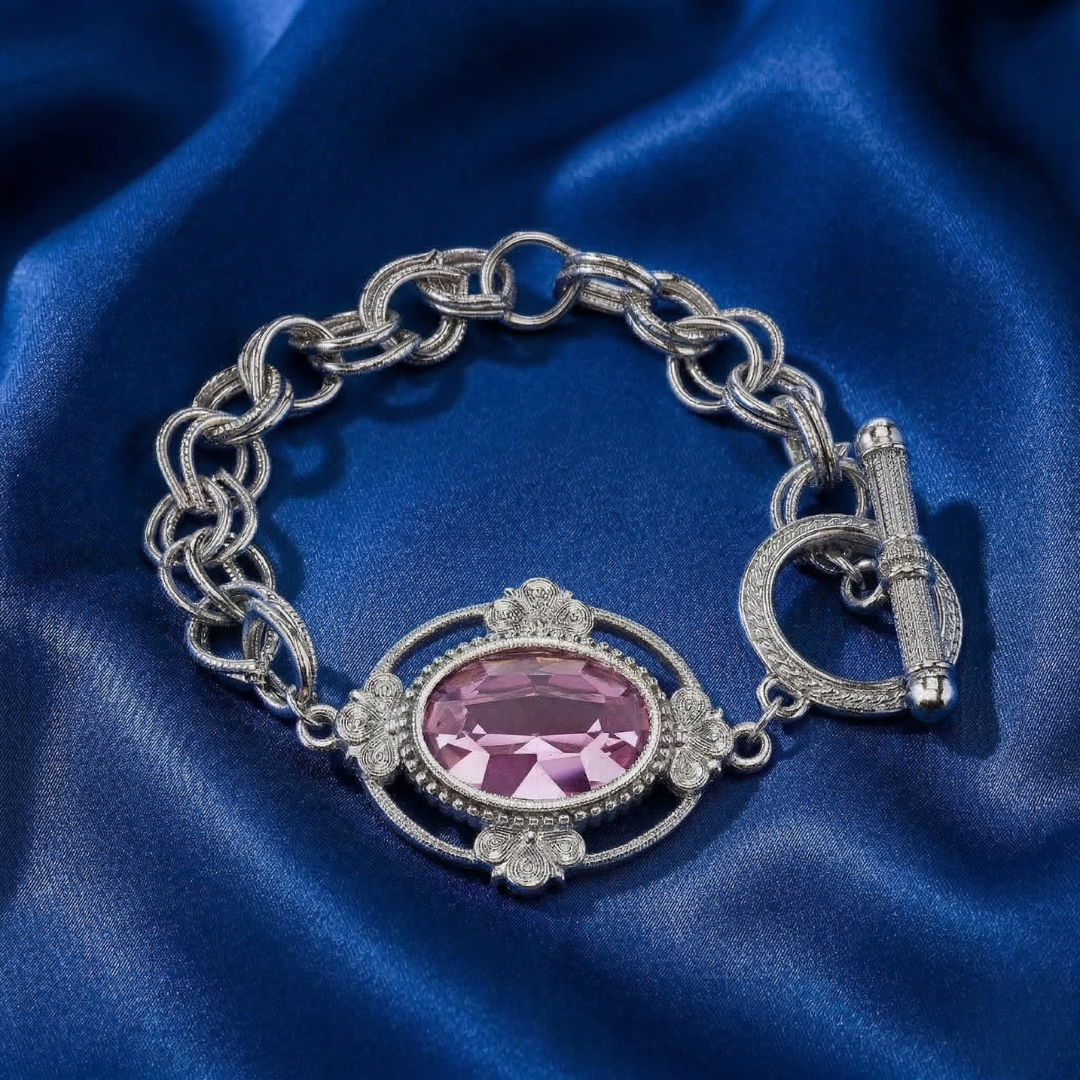 Silver bracelet with a pink crystal on blue satin fabric