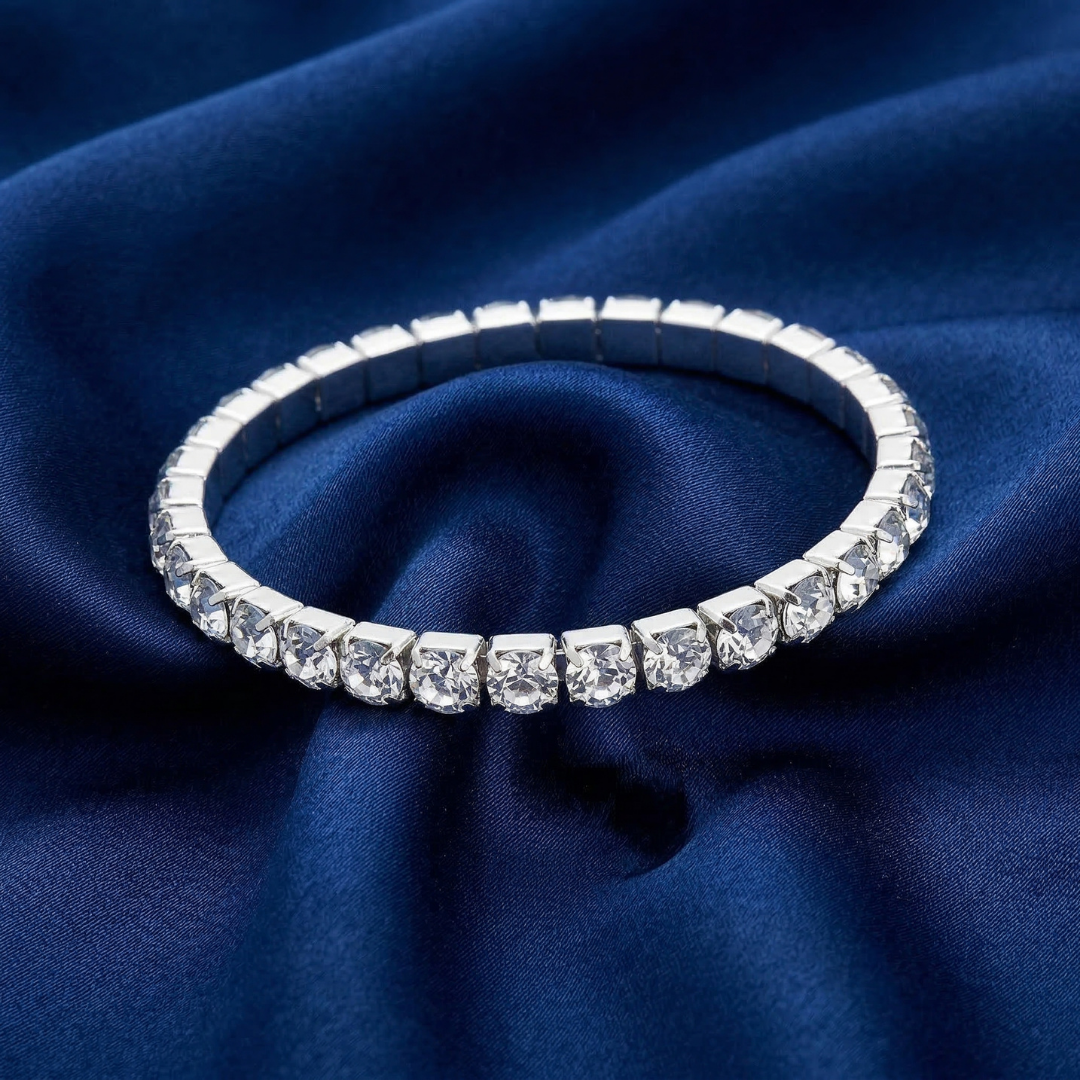 Silver bracelet with clear crystals on a blue fabric background