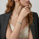 Woman wearing a silver tone horse head design spring cuff bracelet with a clear crystal accent