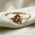 Gold tone vineyard wine grapes bracelet resting on white linen