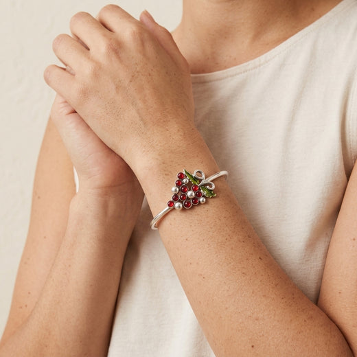 Close-up of a person wearing a silver tone vineyard grapes bracelet