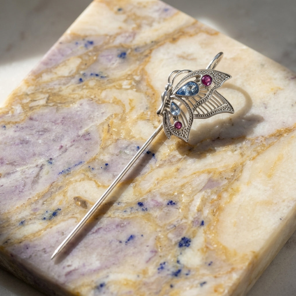Decorative butterfly bookmark with blue and purple crystals on a marble surface