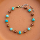 Howlite Dyed Turquoise Gemstone Copper Beaded Bracelet displayed on a terracotta background.