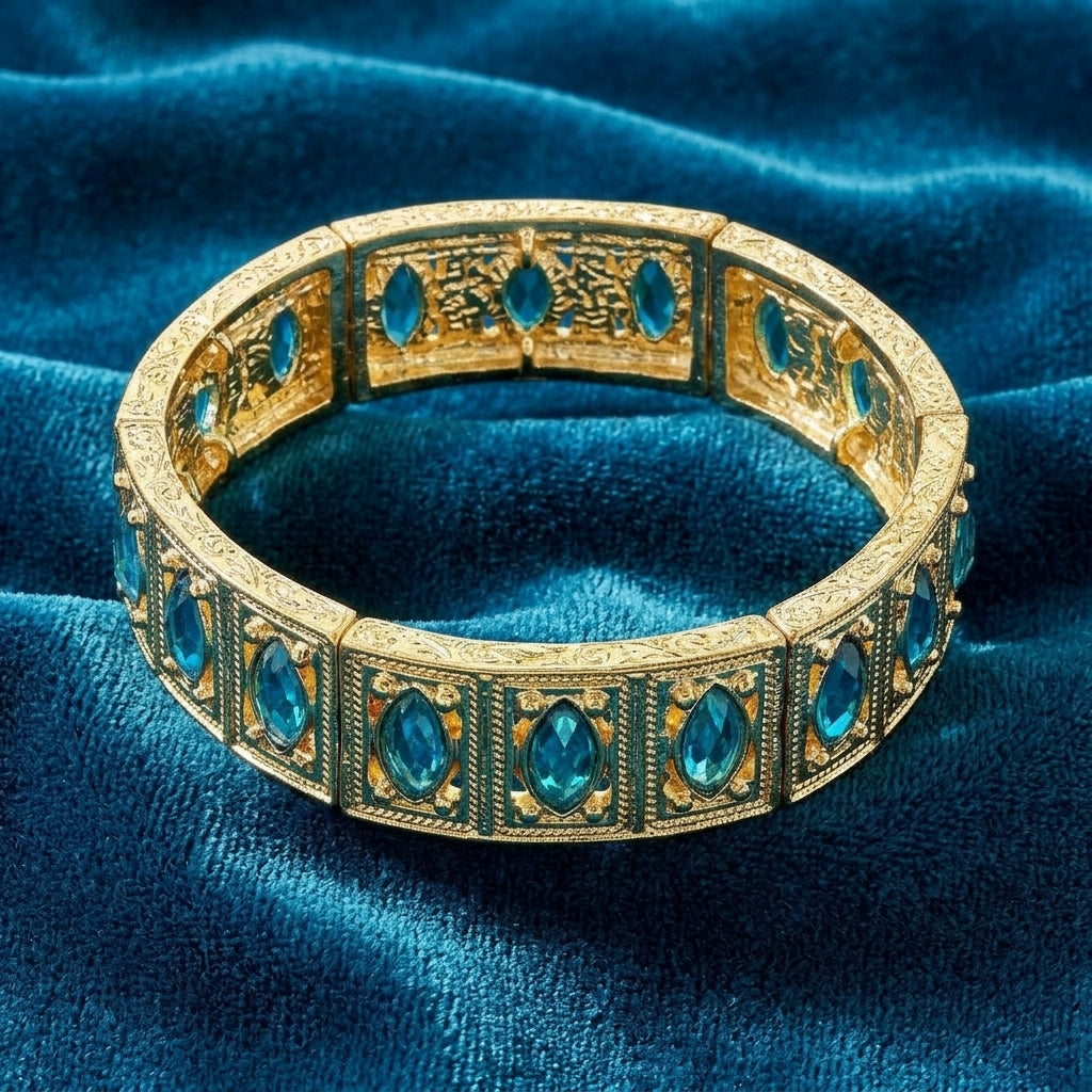 Gold tone aqua blue crystal bracelet on blue fabric 