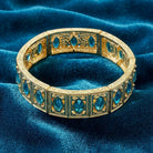 Gold tone aqua blue crystal bracelet on blue fabric 