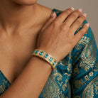 Woman wearing a gold tone aqua blue crystal bracelet
