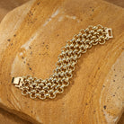 Polished Gold Mesh Chain Bracelet on a textured stone surface