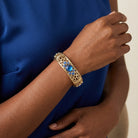 Gold Tone Blue Genuine Mother Of Pearl Crystal Accent Stretch Bracelet on a person wearing a blue dress.