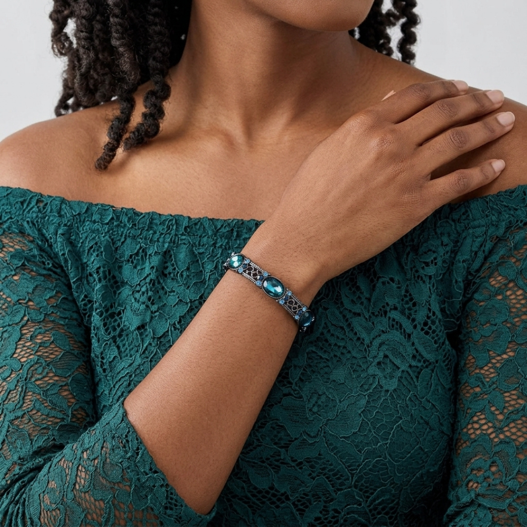 Woman wearing a teal lace dress with a blue crystal bracelet on her wrist.