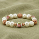 Rose Faux Pearl Purple Flower Filigree Beaded Stretch Bracelet on a textured green fabric background