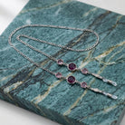 Round Purple Austrian Crystal Channel Eyeglass Holder Chain Necklace on blue marble stone surface