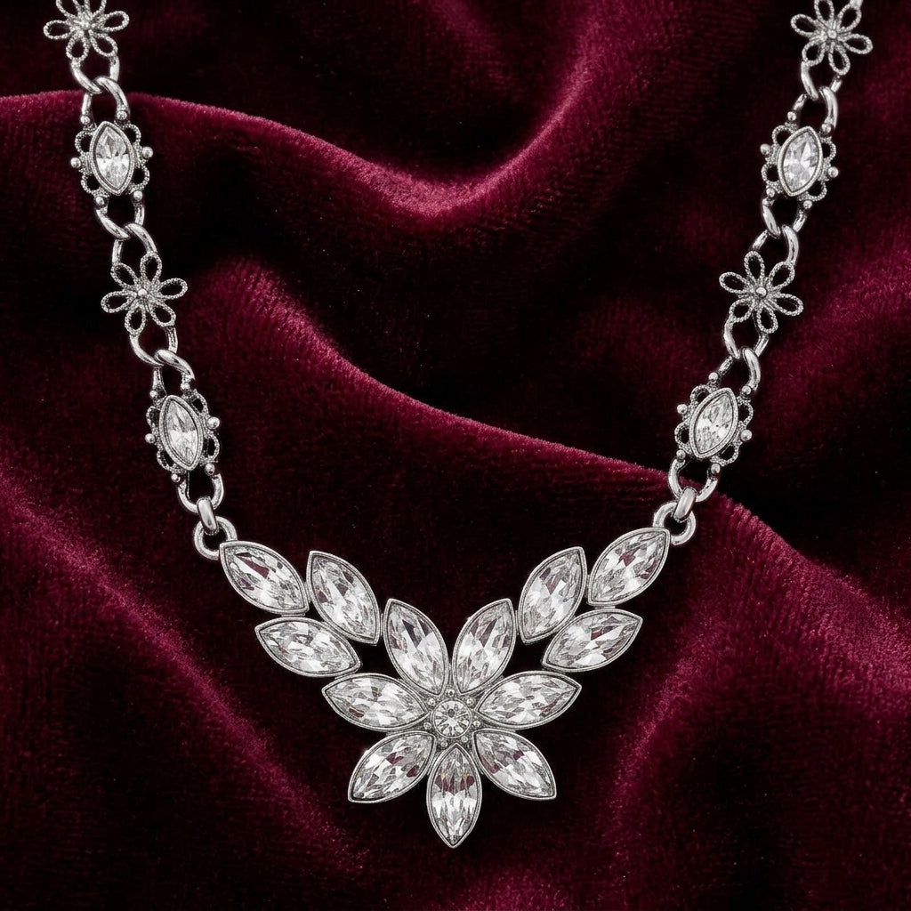 Silver crystal necklace with a floral design on a burgundy fabric background