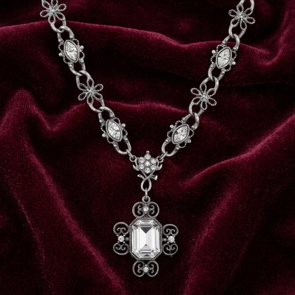 Elegant silver necklace with a large octagon clear crystal pendant on a burgundy velvet background
