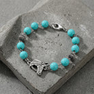Southwest Turquoise Bead Horse Head Link Bracelet on a concrete surface