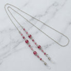 Coral And Pink Bead Eyeglass Holder Chain Necklace on a marble surface