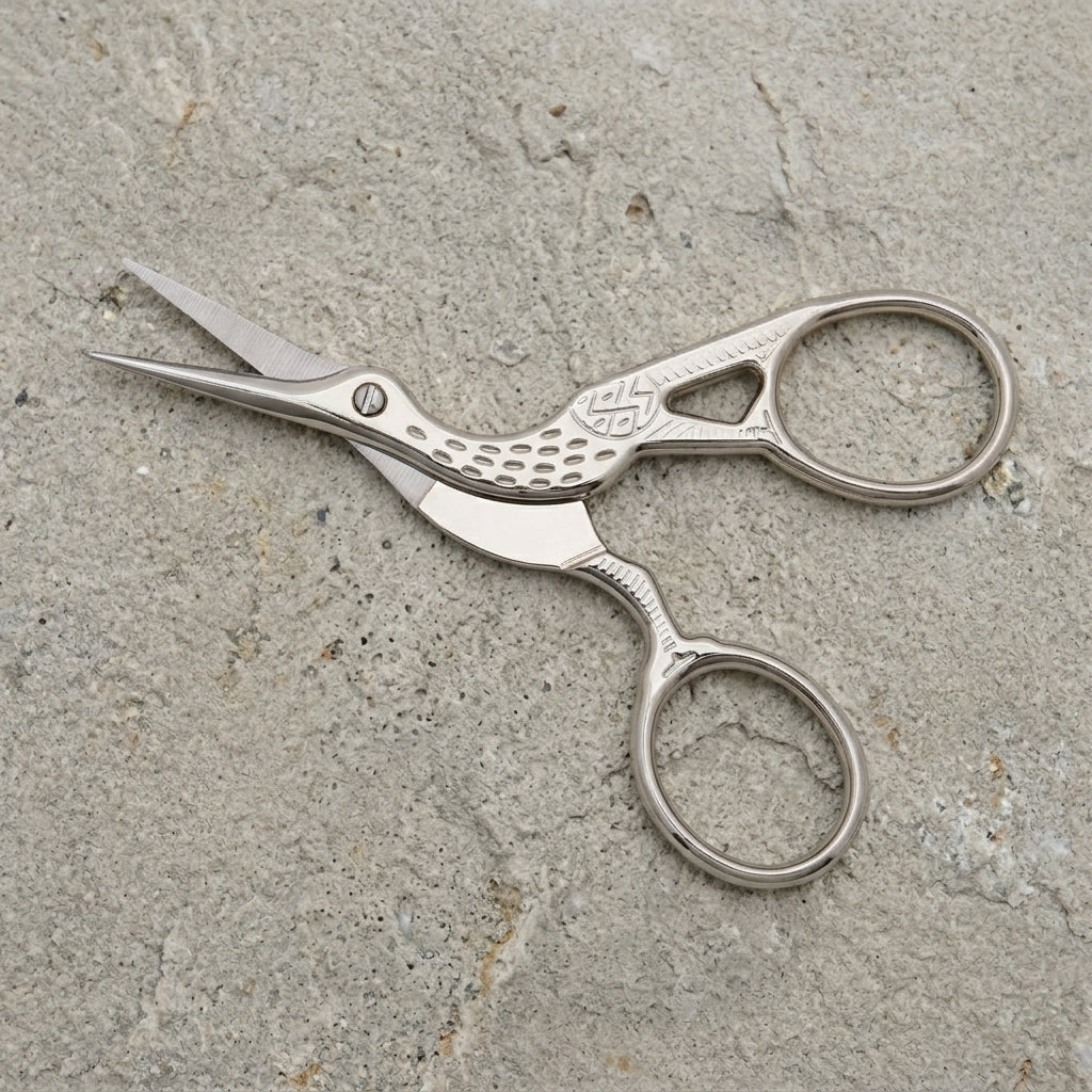 Crane Bird Designed Scissors With Pouch on a textured stone surface